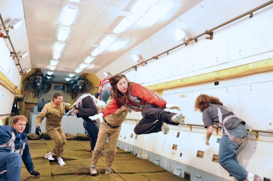 6 people floating around inside an airplane compartment