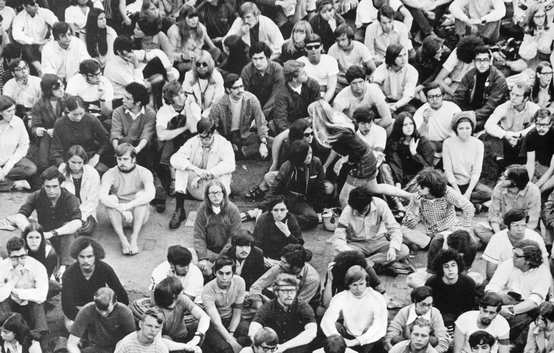 People sit across a sidewalk in protest in 1970