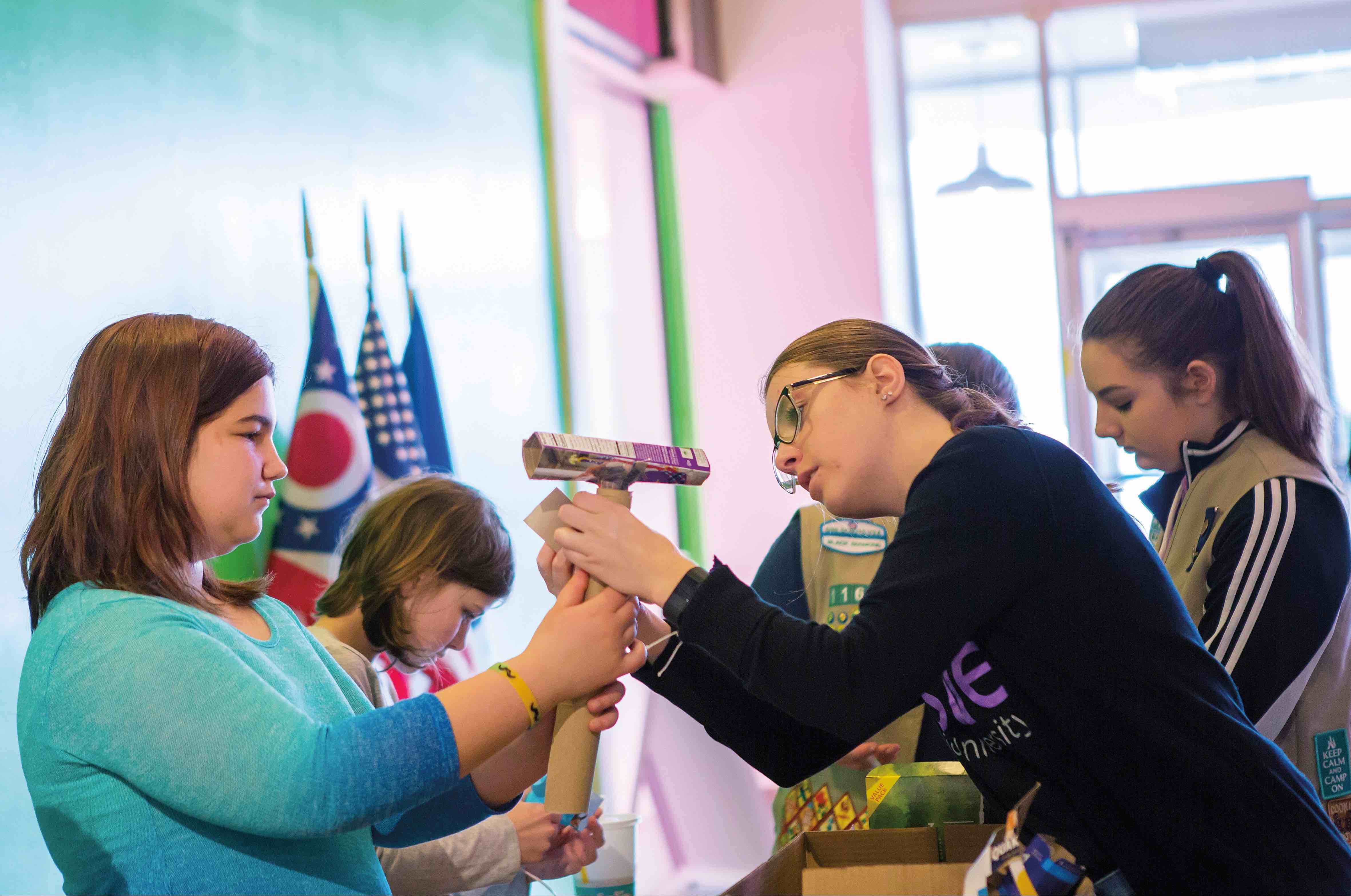 Chemical engineering senior and Society of Women Engineers President Ashley Weitzel helps an Athens-area Girl Scout assemble a Rube Goldberg machine at the groups’ “Buildings, Brains, and Boxes” design contest