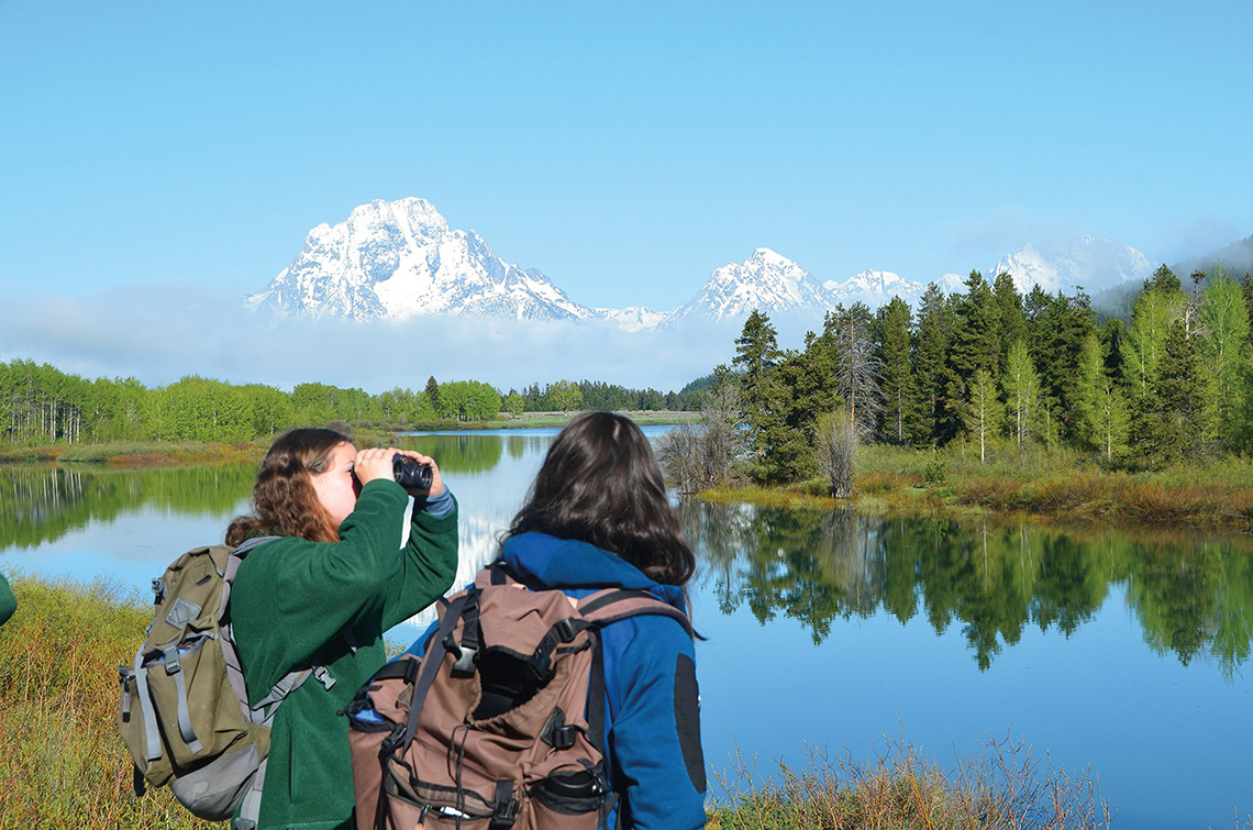 Grace Cahill spots birds at Oxbow Bend in Grand Teton National Park—a popular fauna-spotting location—while Lou Duloisy watches Mount Moran emerge from behind the morning fog