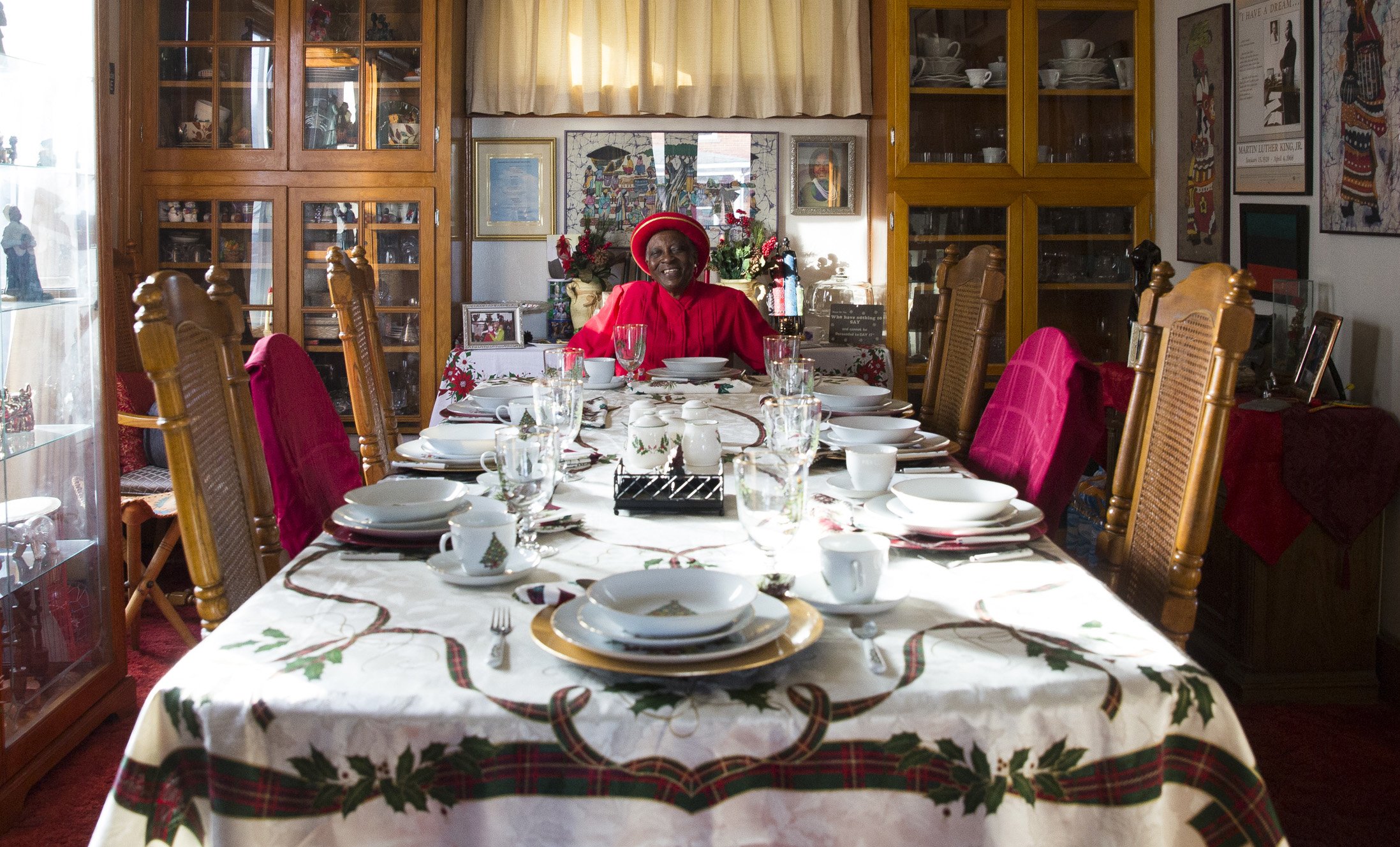 A woman sits at the head of a set table