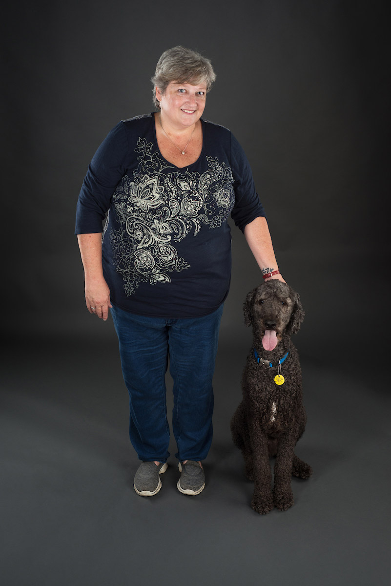 Rinda Scoogan posing with her 9 year old standard poodle therapy dog, Buddy