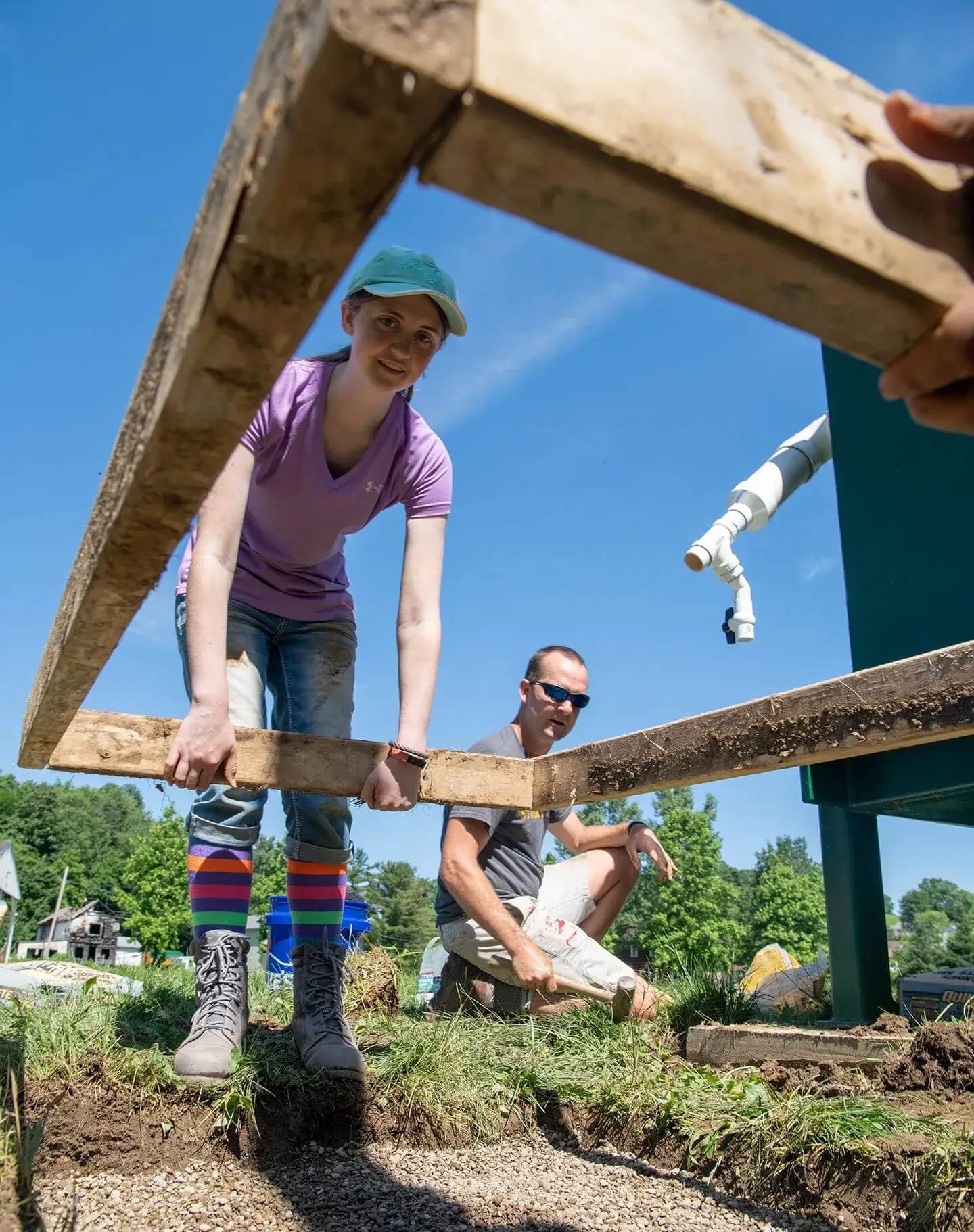 Two people holding wooden frame up