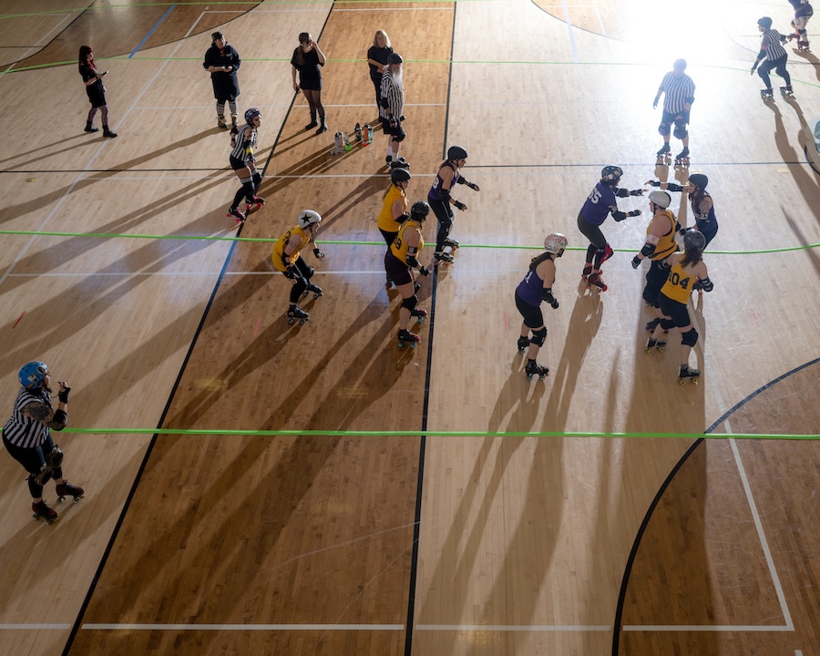 Wide shot of roller derby played on a gym floor