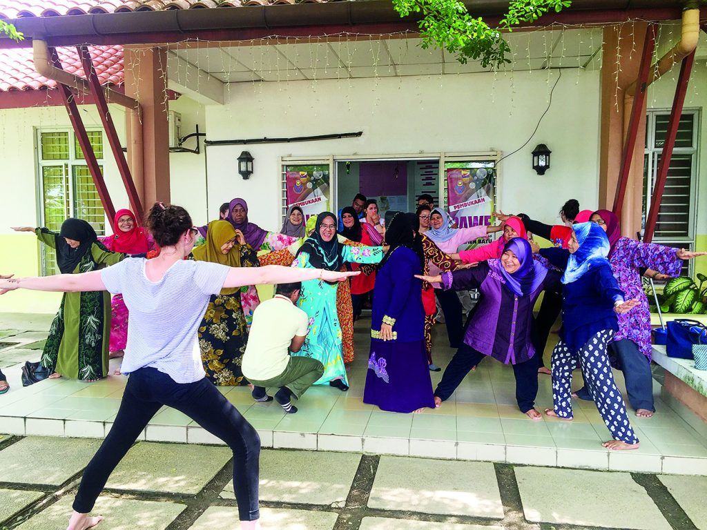 Hanna Smith, BSCSD ’17, leads a yoga session at PAWEBatu Adult Day Center in Kuala Lumpur, Malaysia, during the May 2017 GHI trip. Photo by Brooke Hallowell