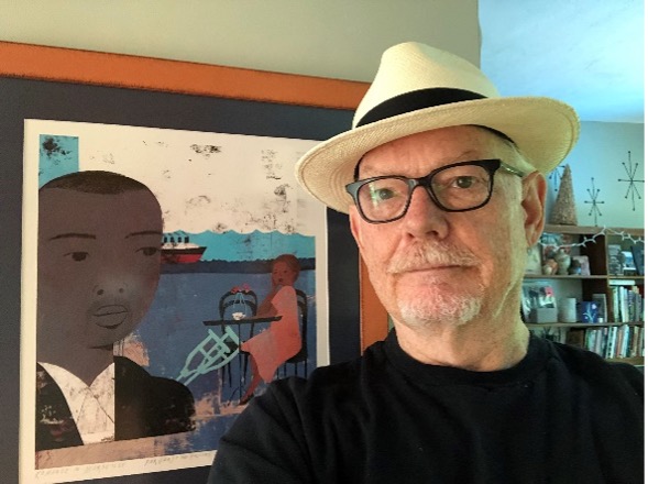 Gary Holcomb poses with a framed copy of the artwork for the novel 