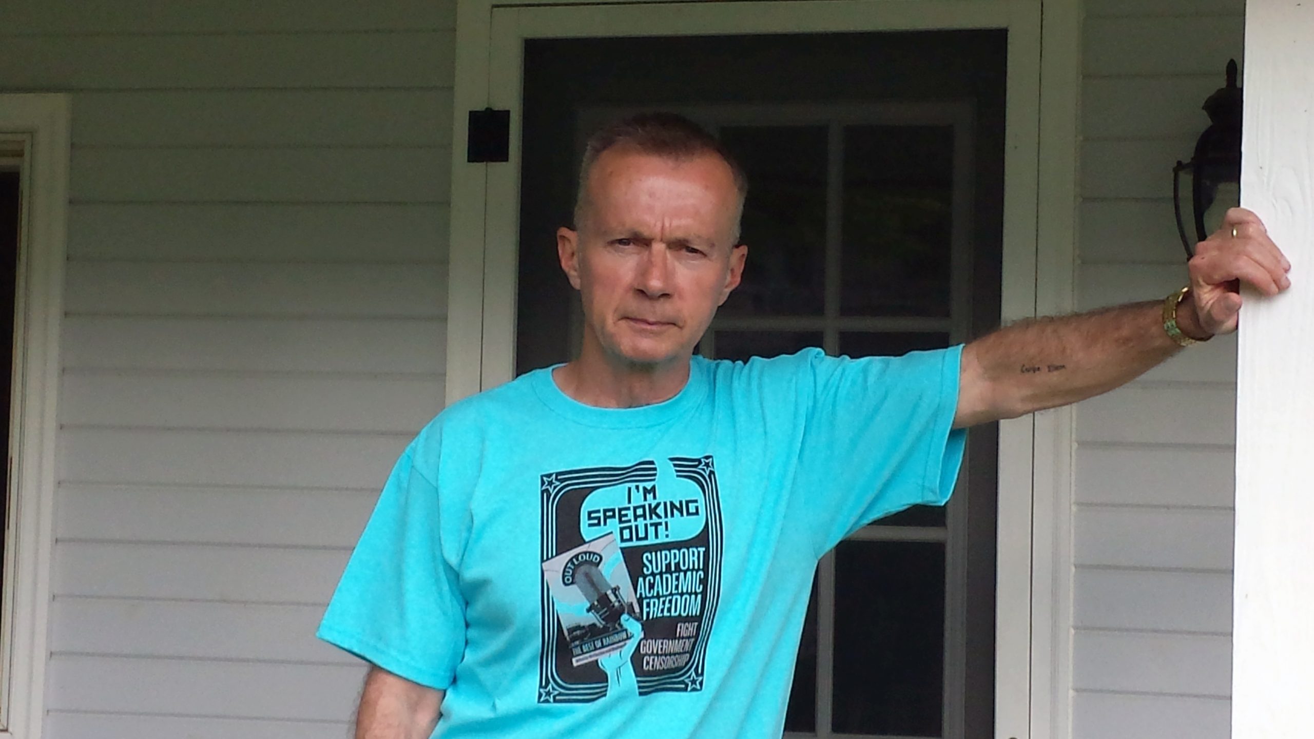 Donald Pollock leaning on a pole outside of a home.