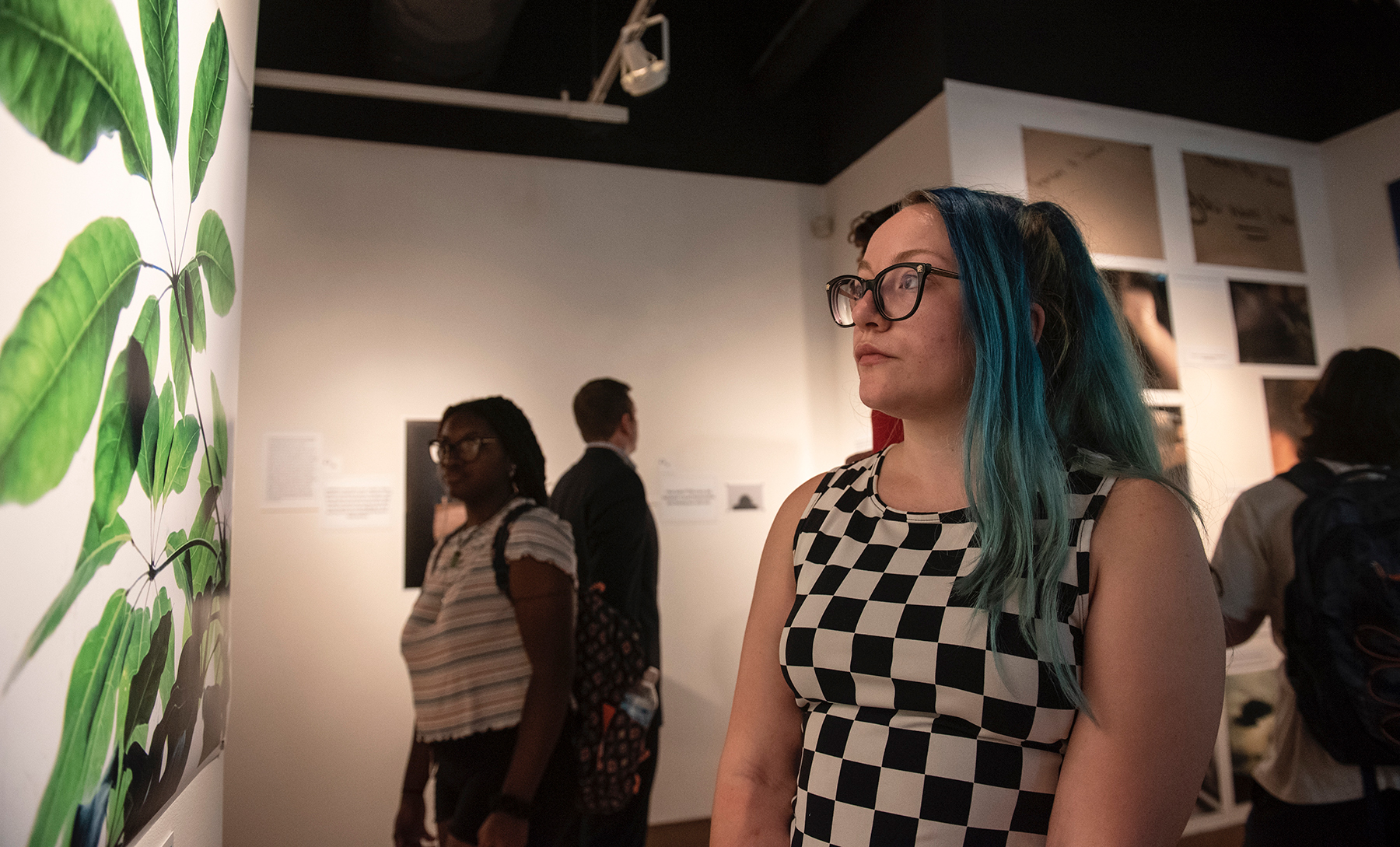 Students view the exhibit called Through the Survivors' Lens