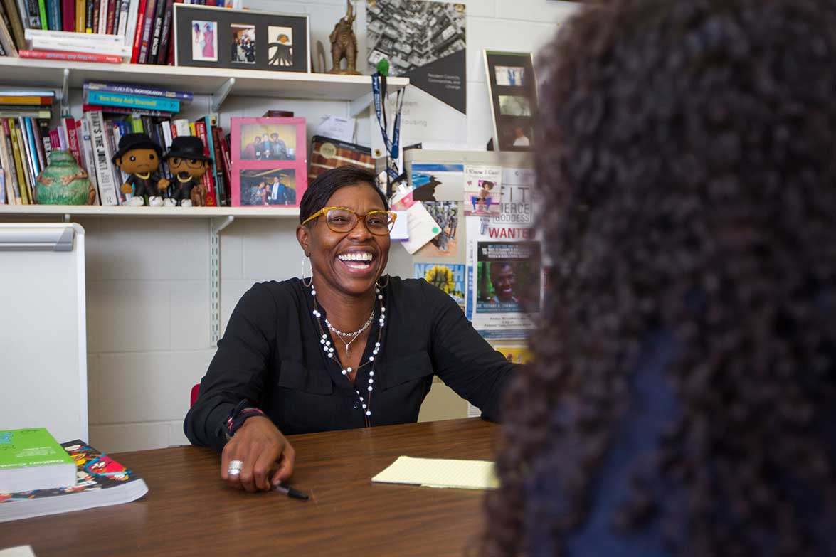 Tiffany Chenault, AB ’96, visits with a student in her Salem State University office.