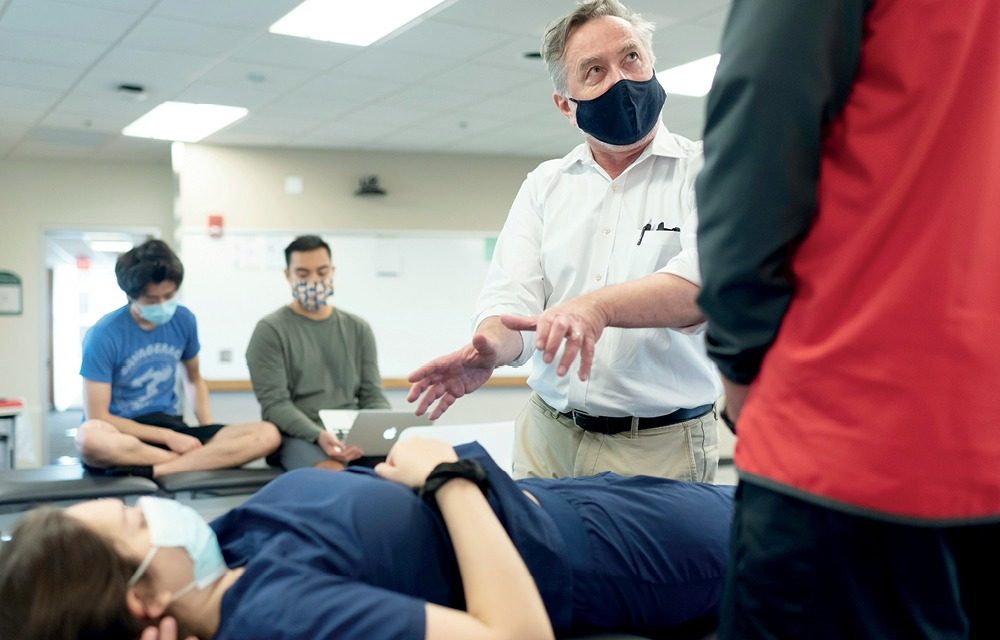 Professor instructing 3 students during a lab