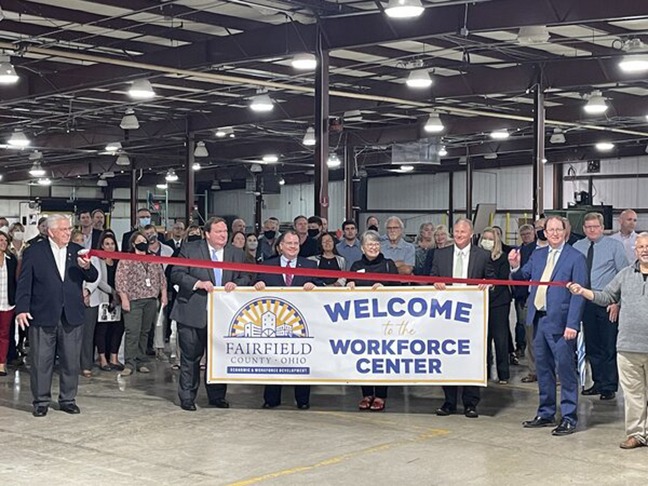 workers inside of a warehouse holding a banner saying "Welcome to the workforce center. Fair Field County Ohio" 