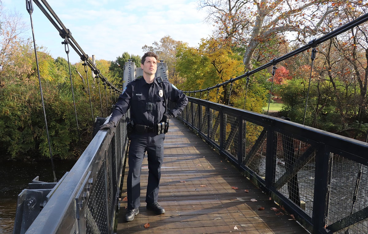 Officer Mike Regan, played by Nick Steen, stands on a bridge featured in the episode, 