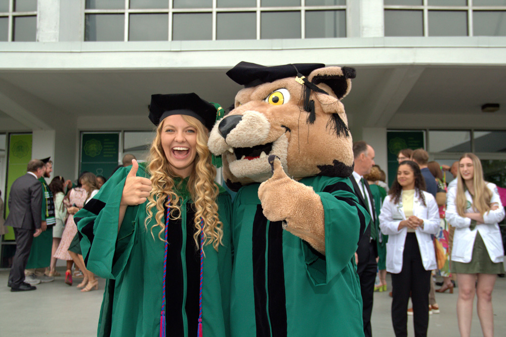 HCOM graduate and Dr. Rufus celebrate at 2024 commencement