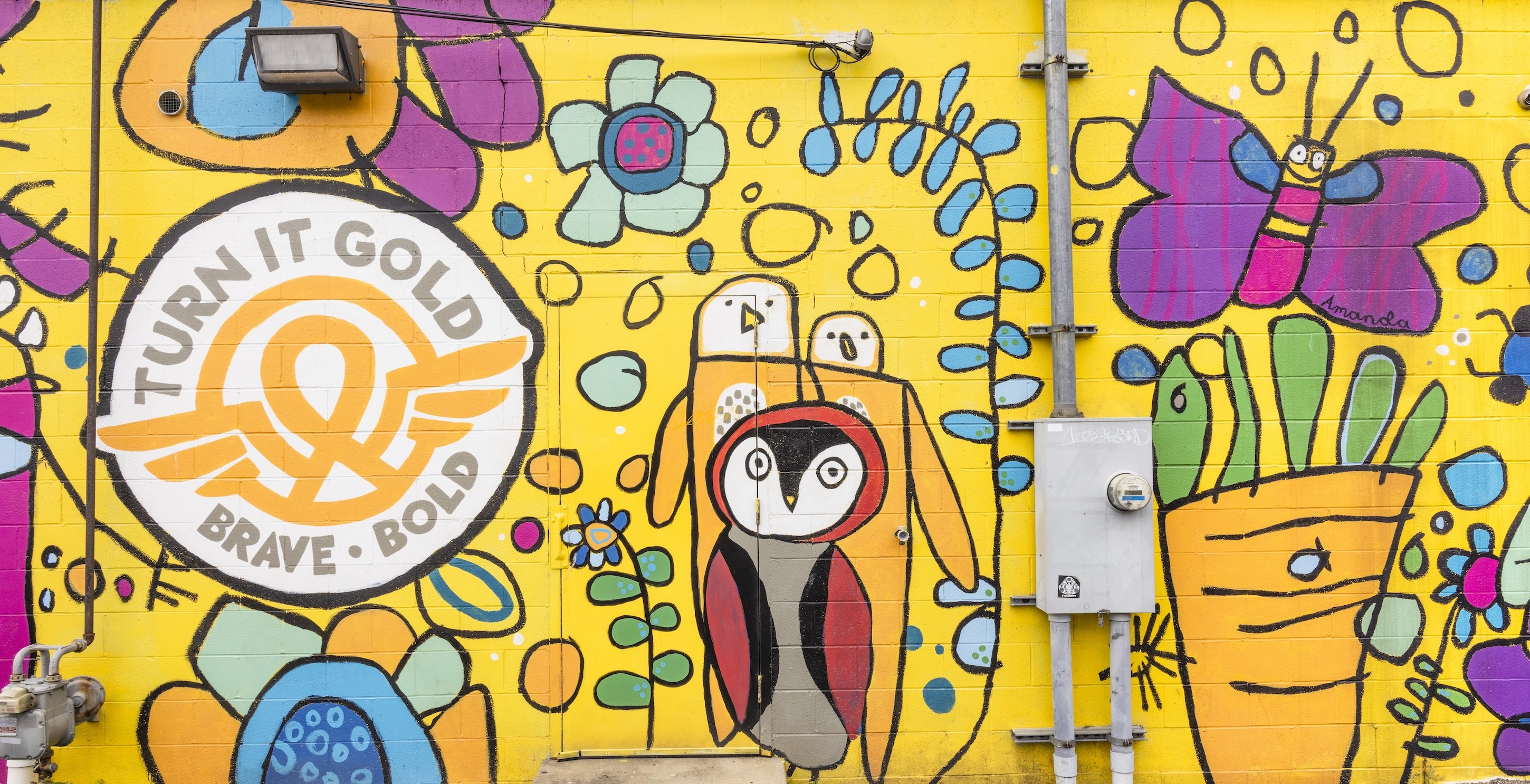 A colorful mural featuring animals and butterflies, with the words 