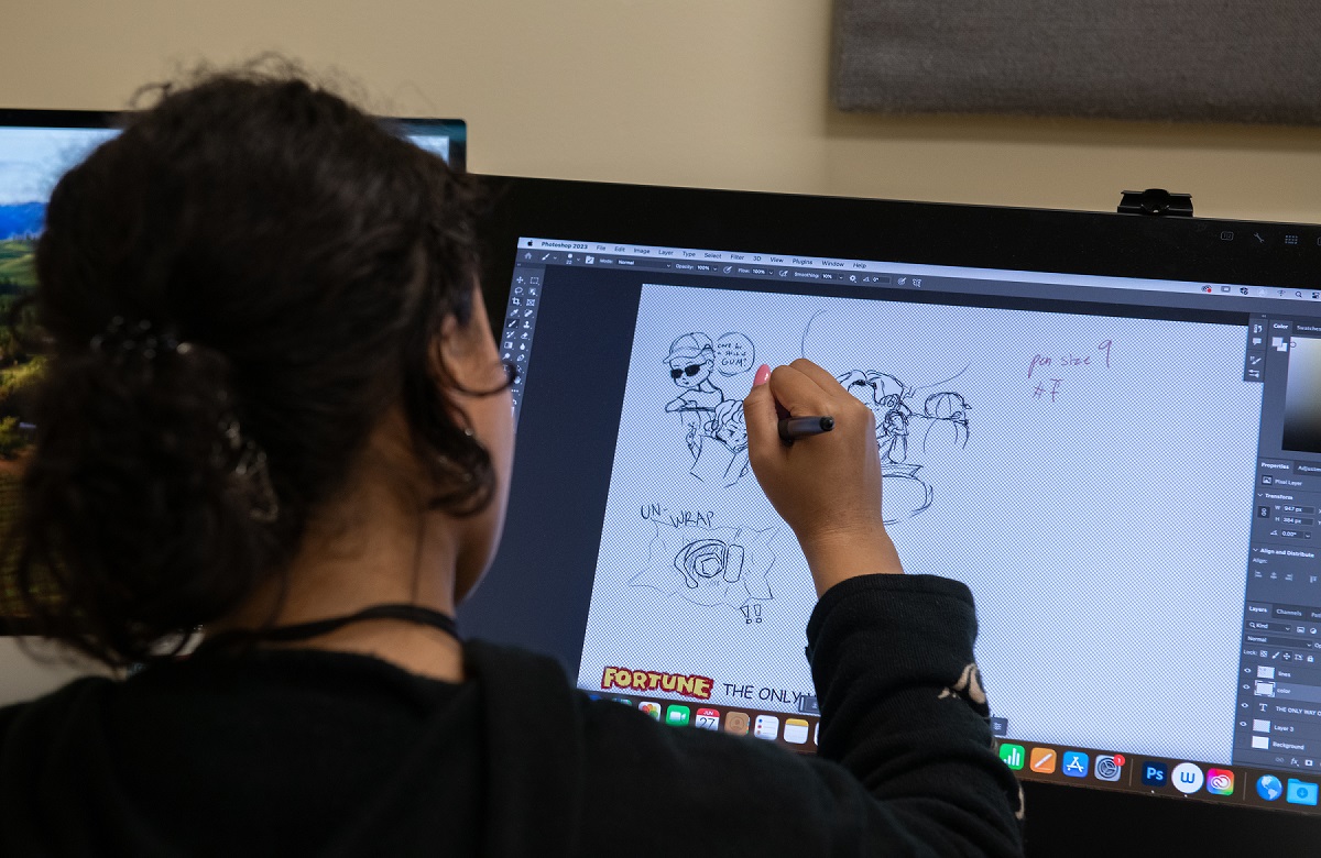 A student creates an illustration during the High School Media Workshop