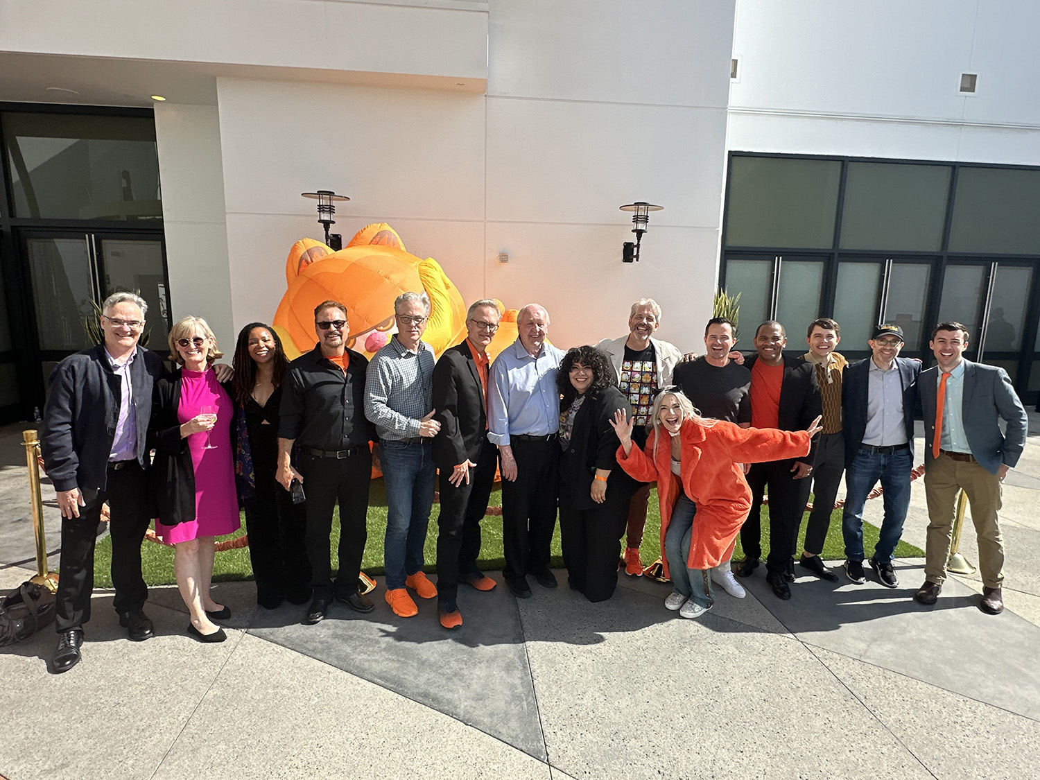 a group of movie industry professionals pose outside in front of an inflatable Garfield figure