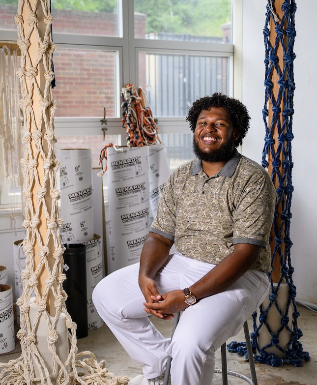 Student poses with his award winning sculpture