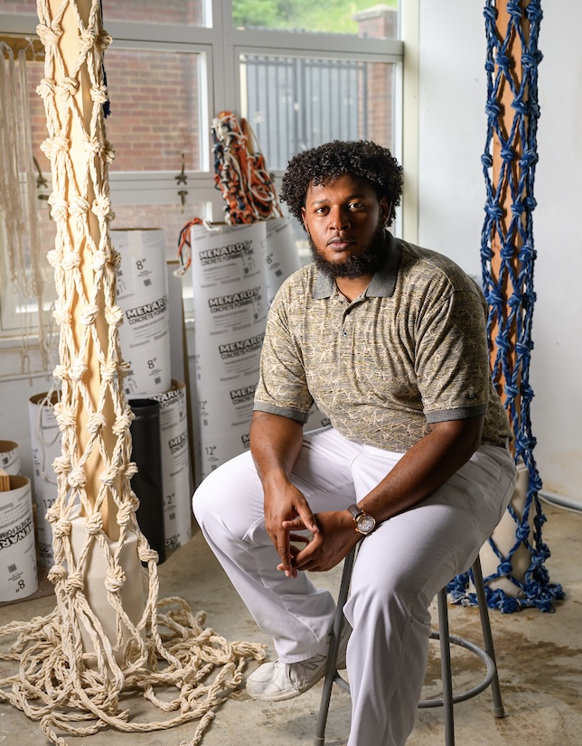 Student poses with his award winning sculpture