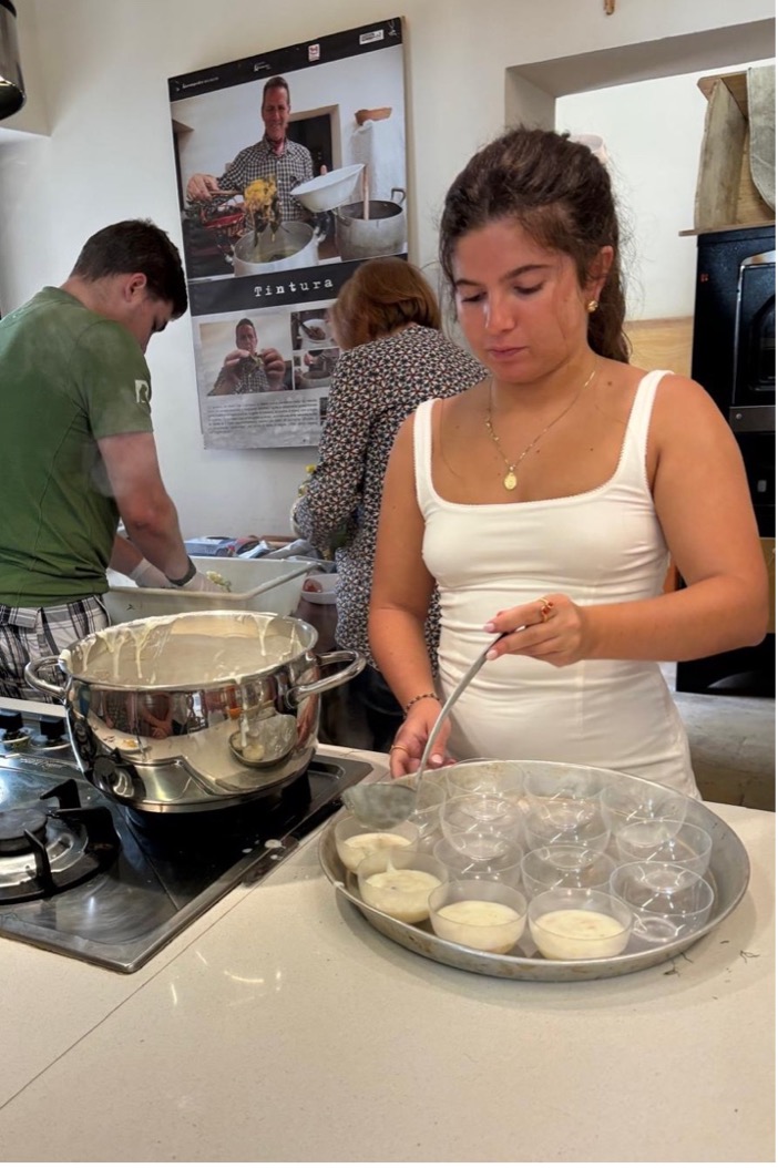 a woman ladles white liquid into glass cups