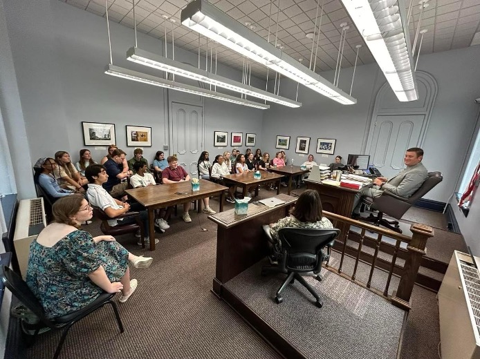 Students gather in a courtroom for a tour