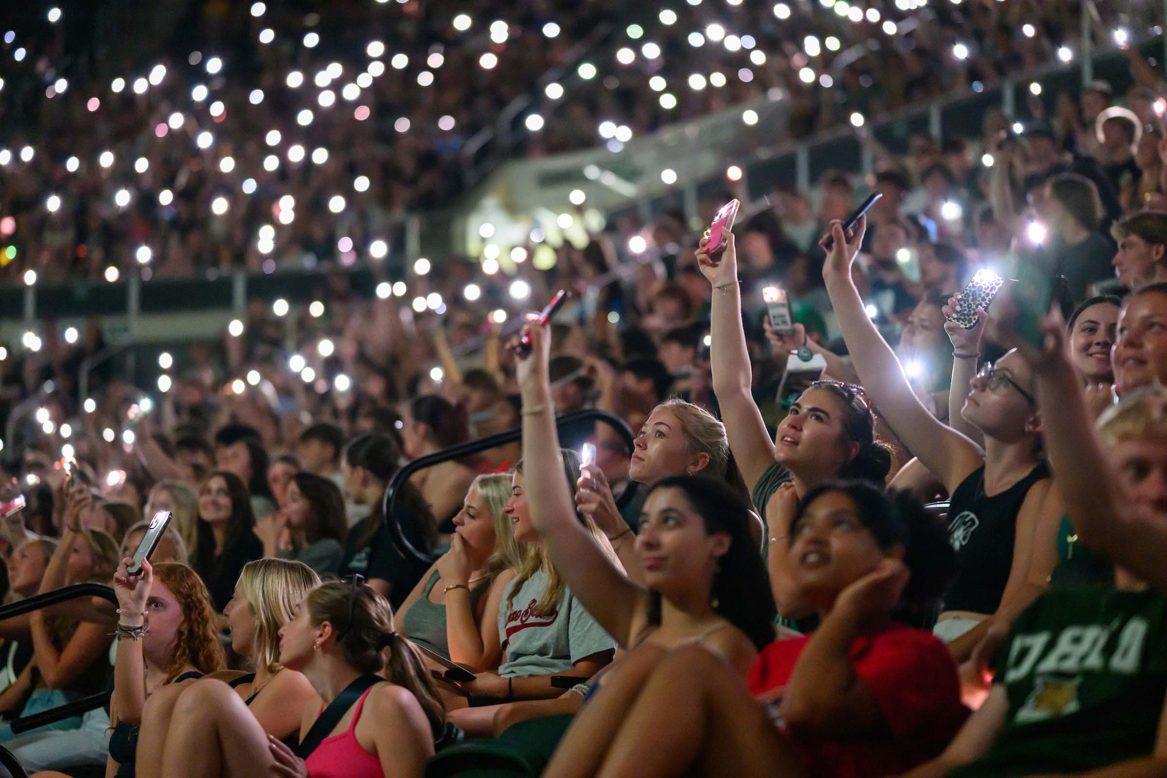 New OHIO students hold up their cell phones with lights on during First-Year Student Convocation.