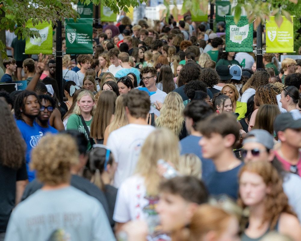 A large crowd of students walks around the Involvement Fair on College Green