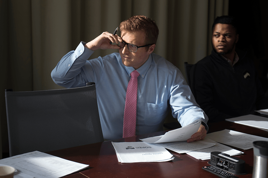 A male accountant lifts his glasses as he surveys the scene during a SOPEC meeting at Ohio University