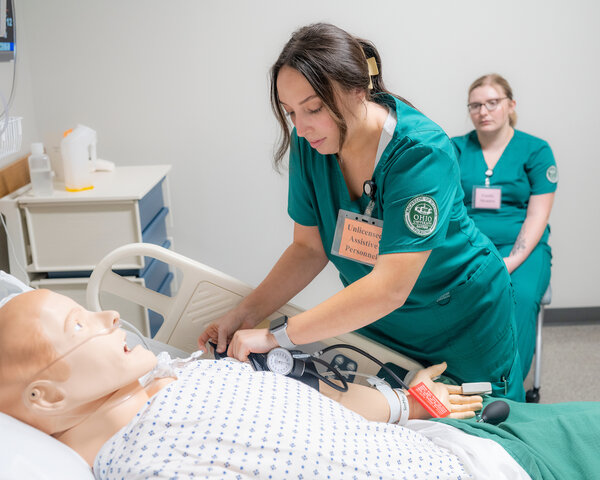 Students in the nursing program practice a simulation. 