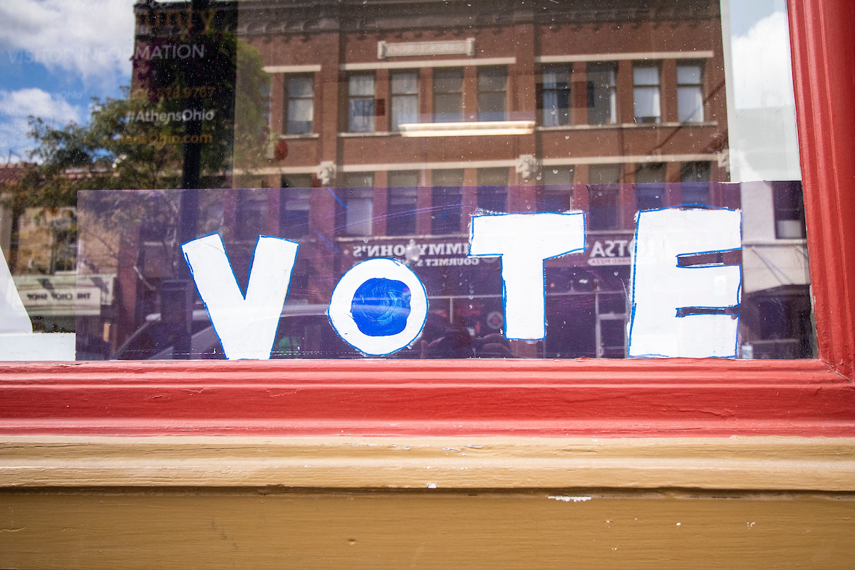 A hand-lettered sign reading "VOTE," pictured in a window on Court Street in Athens, Ohio