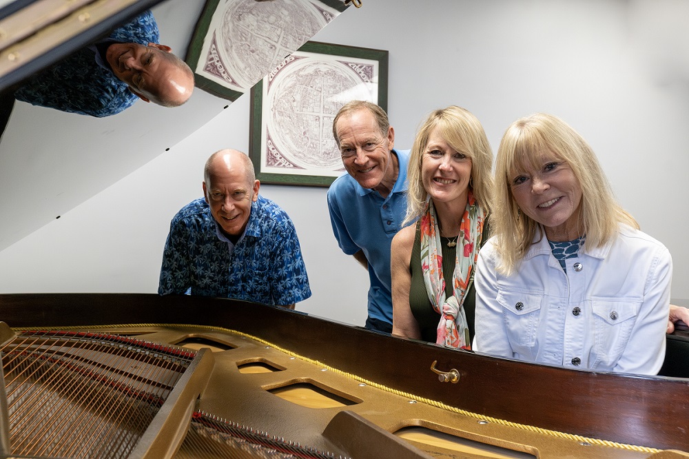 Family members stand next to the grand piano