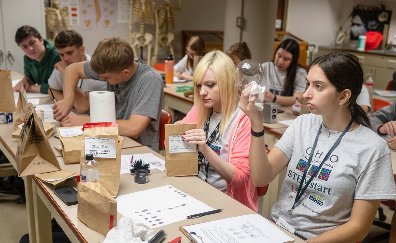 Incoming first-year college students analyze crime kits in a lab