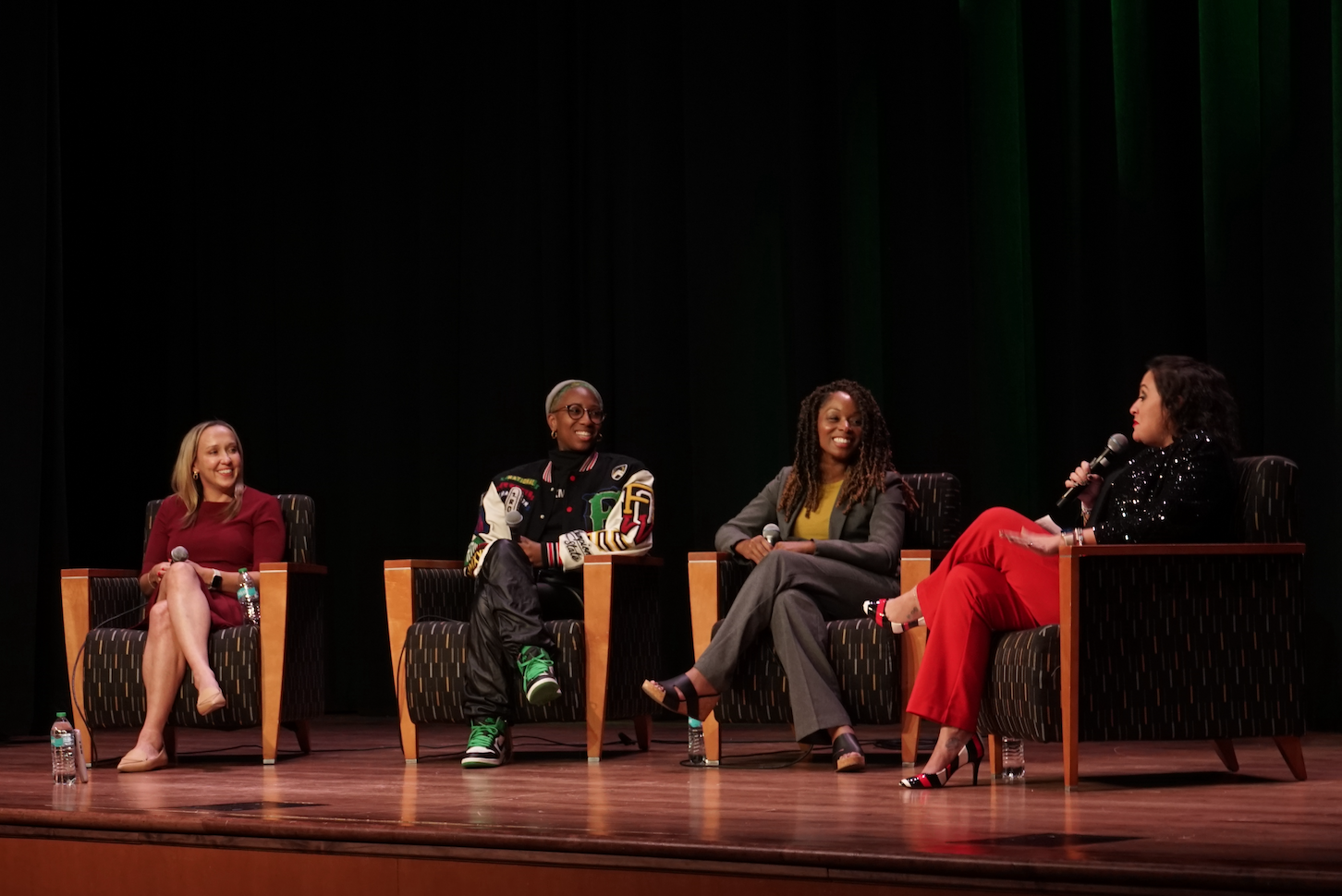 Four women sit on stage for a panel event