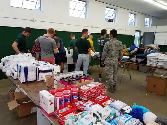 Volunteers stand in the background of essential supplies to help the homeless and those in need.