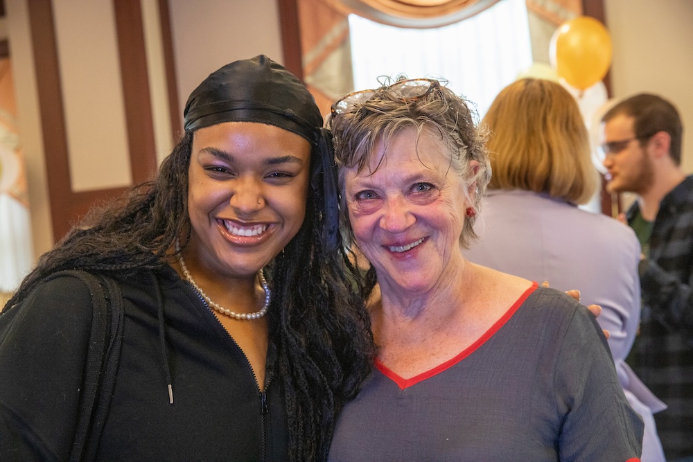 Two women pose, smiling