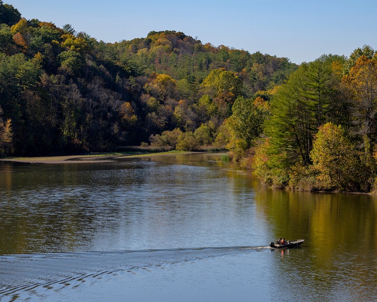 A boat moves across Dow Lake at Strouds Run State Park near Ohio University on a Fall day.