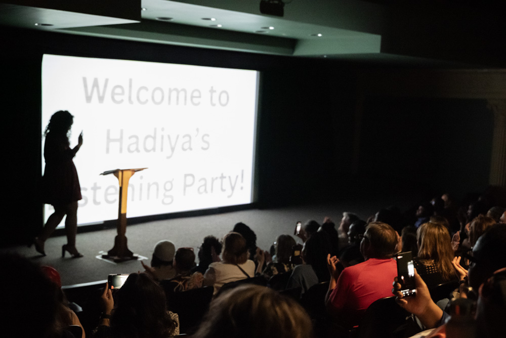 Hadiya Ray walks onstage in front of a large audience