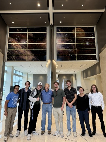 A group of students and NASA employees pose in the Kennedy Space Center lobby