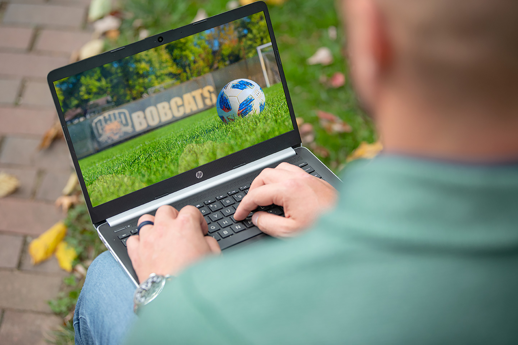 An OHIO Masters in Coaching Education - Soccer student on their laptop outside