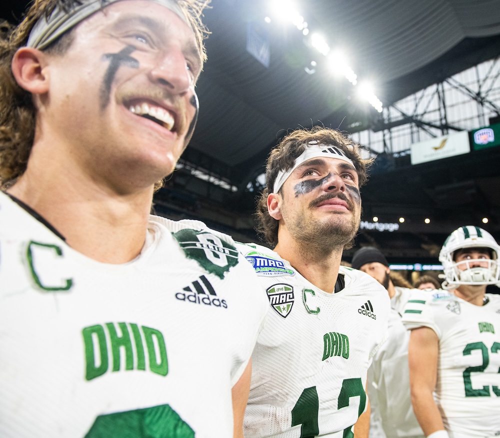 OHIO football players smile with the lights of Ford Field behind them, at the MAC Championship game