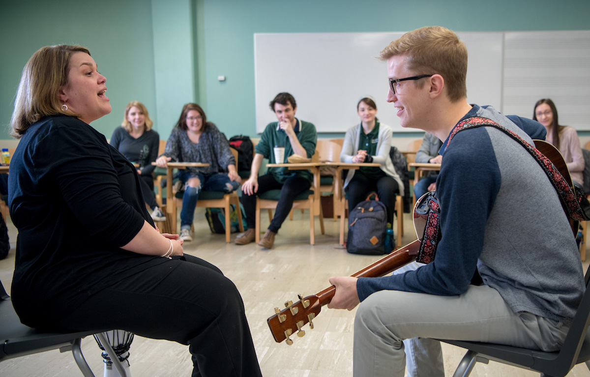 Two participants interacting in front of a music therapy class. 