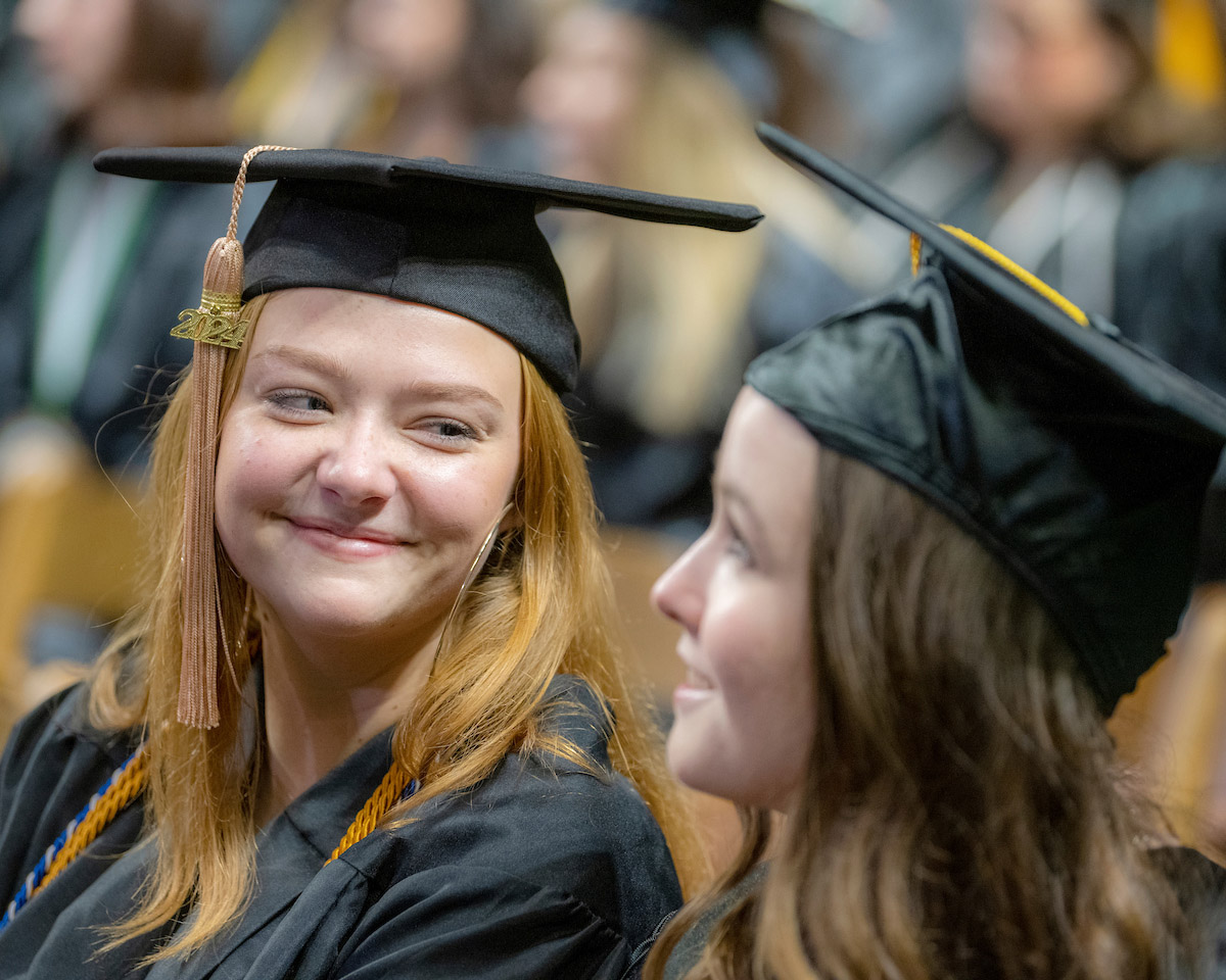 Two female graduates at the Fall 2024 commencement ceremony