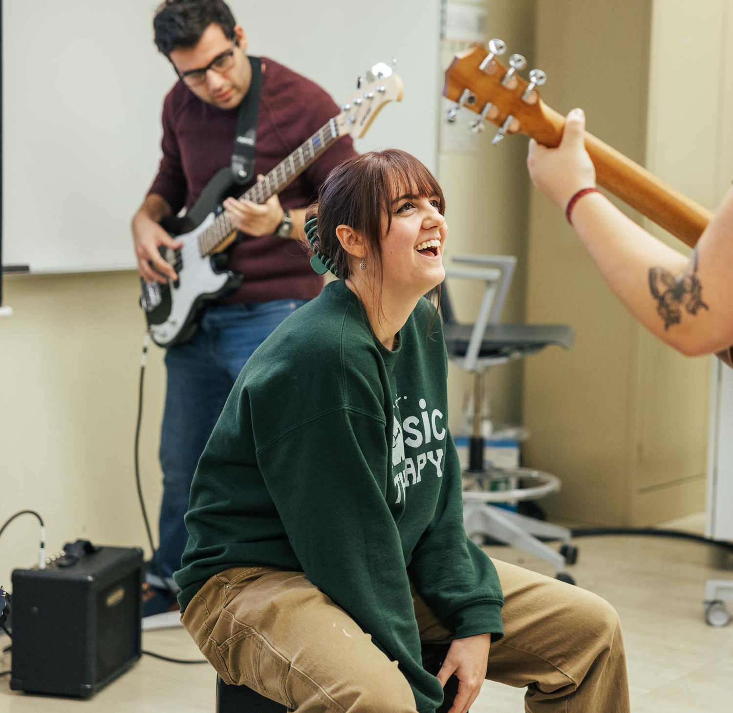 OHIO music therapy students playing together with guitar, bass and cajon.