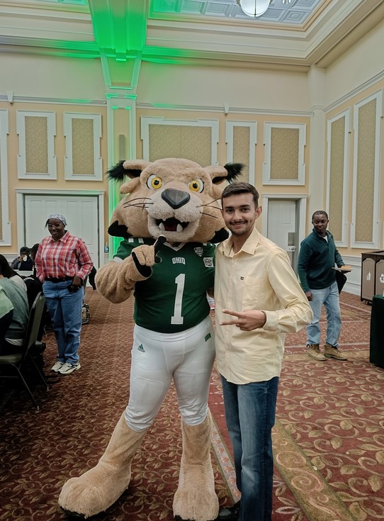 Joshi standing with a Rufus mascot at Baker Center.