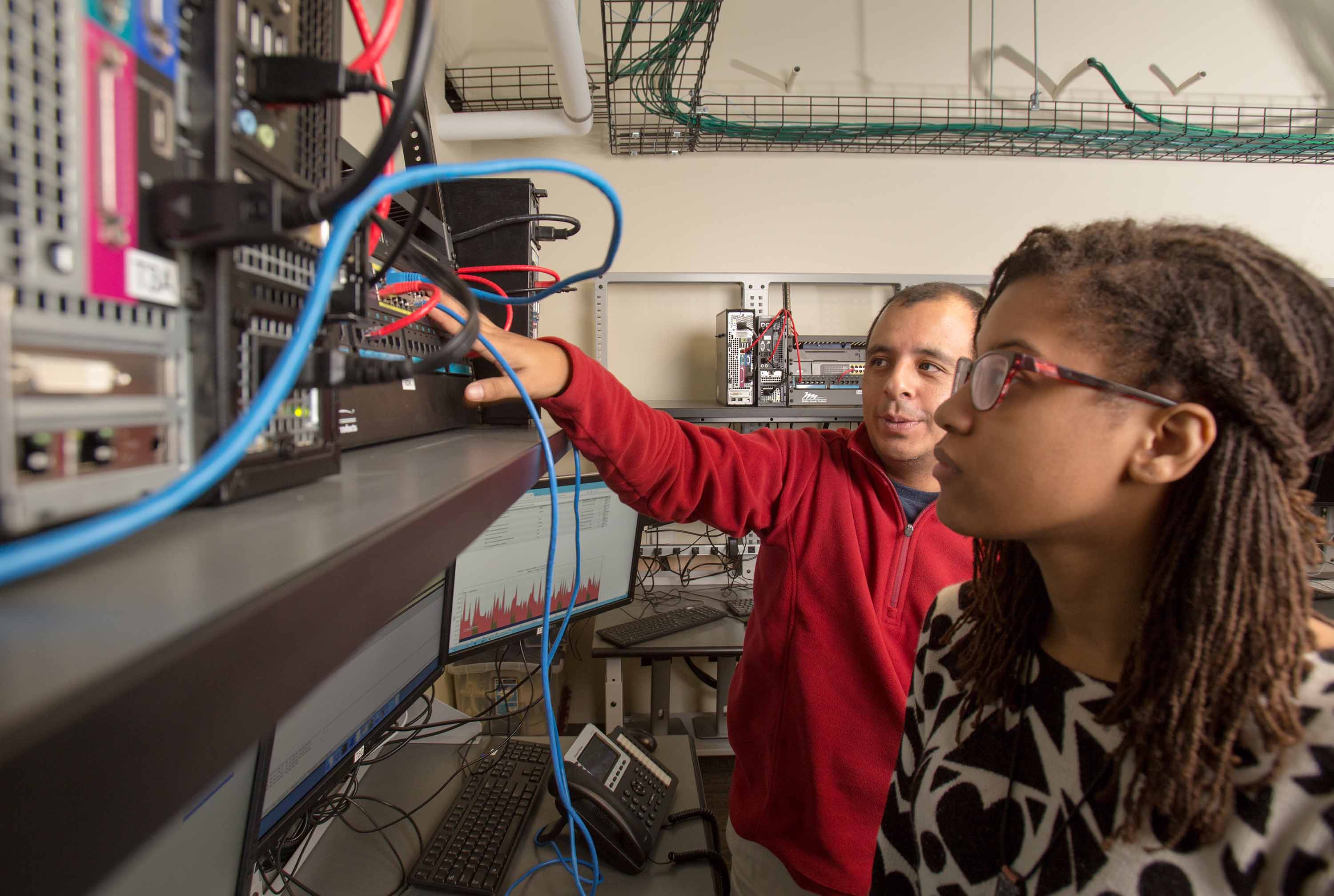 Dr. Julio Arauz works with a student in the McClure School of Emerging Communications Technology.