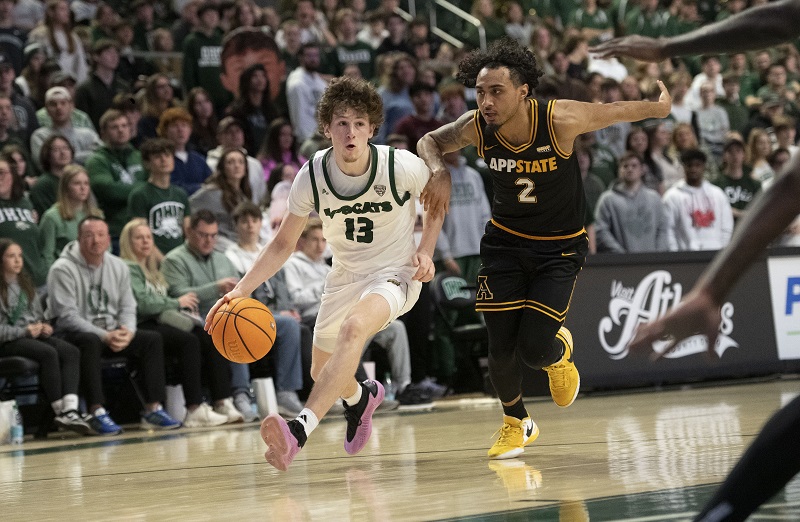 An OHIO basketball players dribbles that ball past an Appalachian State player during a game in the Convocation Center