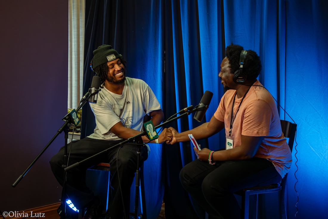 Oyuke shakes hands with an artist during the podcast