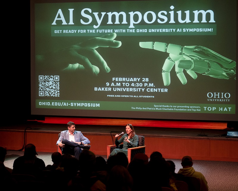 Two speakers lead a discussion at the AI Symposium in the Baker Center Theater