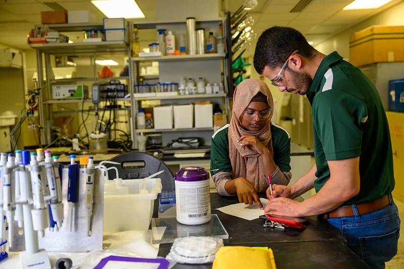 Two OHIO students work on a research project in a mechanical engineering laboratory space