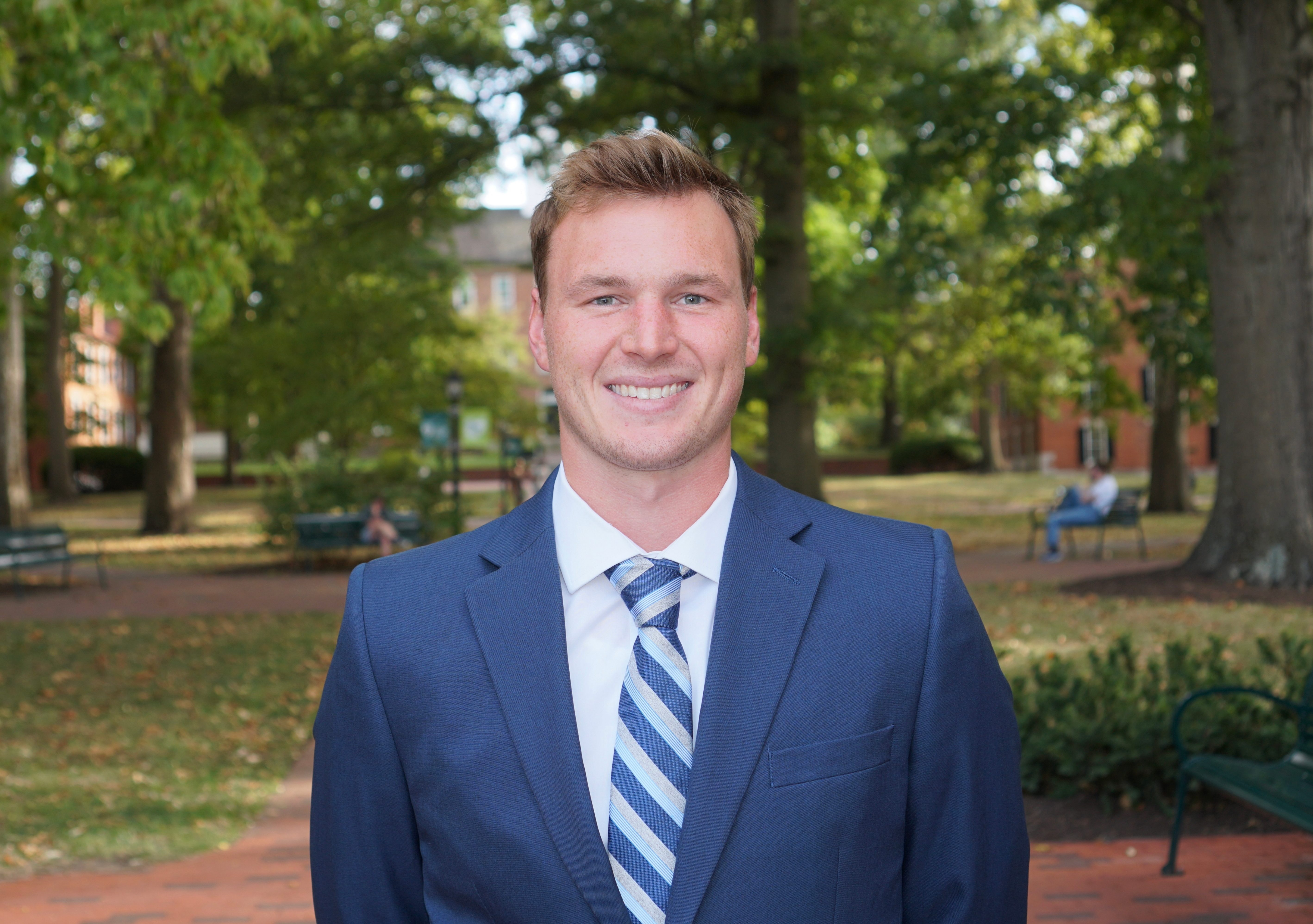 A headshot of a man in a suit.