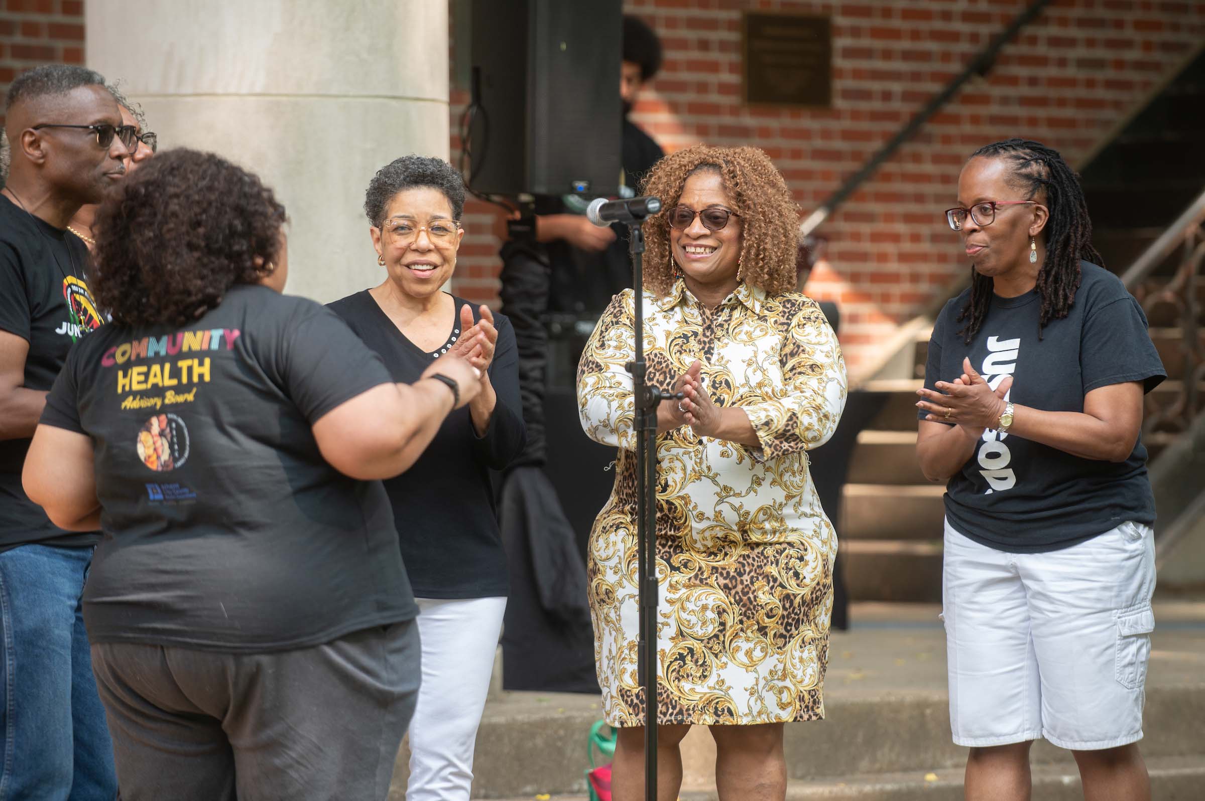 Community members clap and smile during a Juneteenth celebration on College Green at Ohio University.